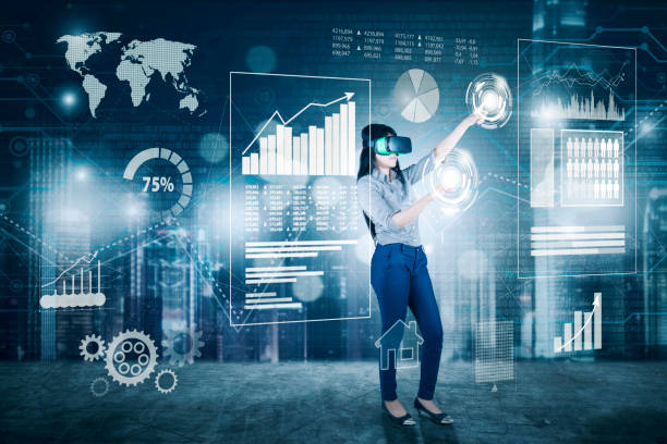 A woman standing in front of a wall with various graphs and data.